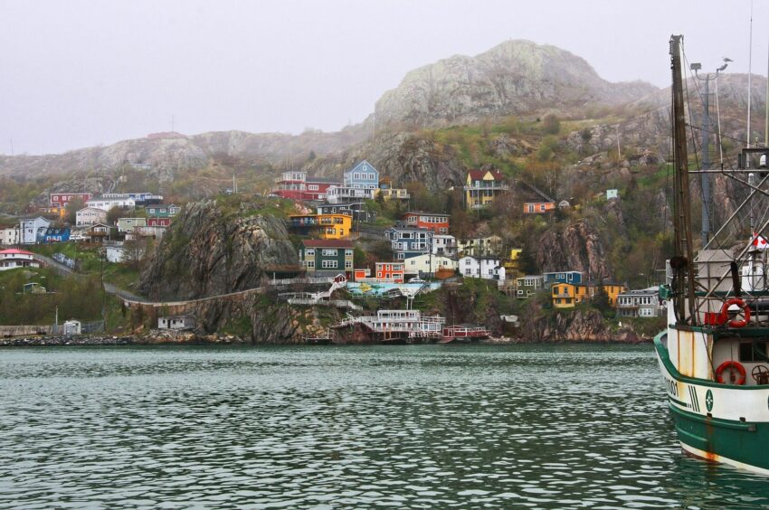harbor ship with coastal houses in the distance.